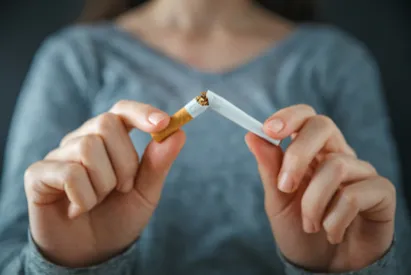Femme cassant une cigarette en deux