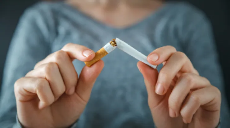 Femme cassant une cigarette en deux
